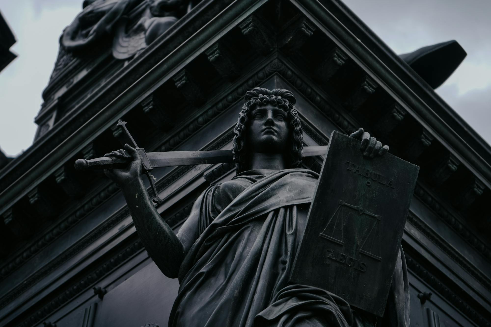 Justitia-Figur mit Schwert und Waage — Symbol für eine konsequente Strafverteidigung